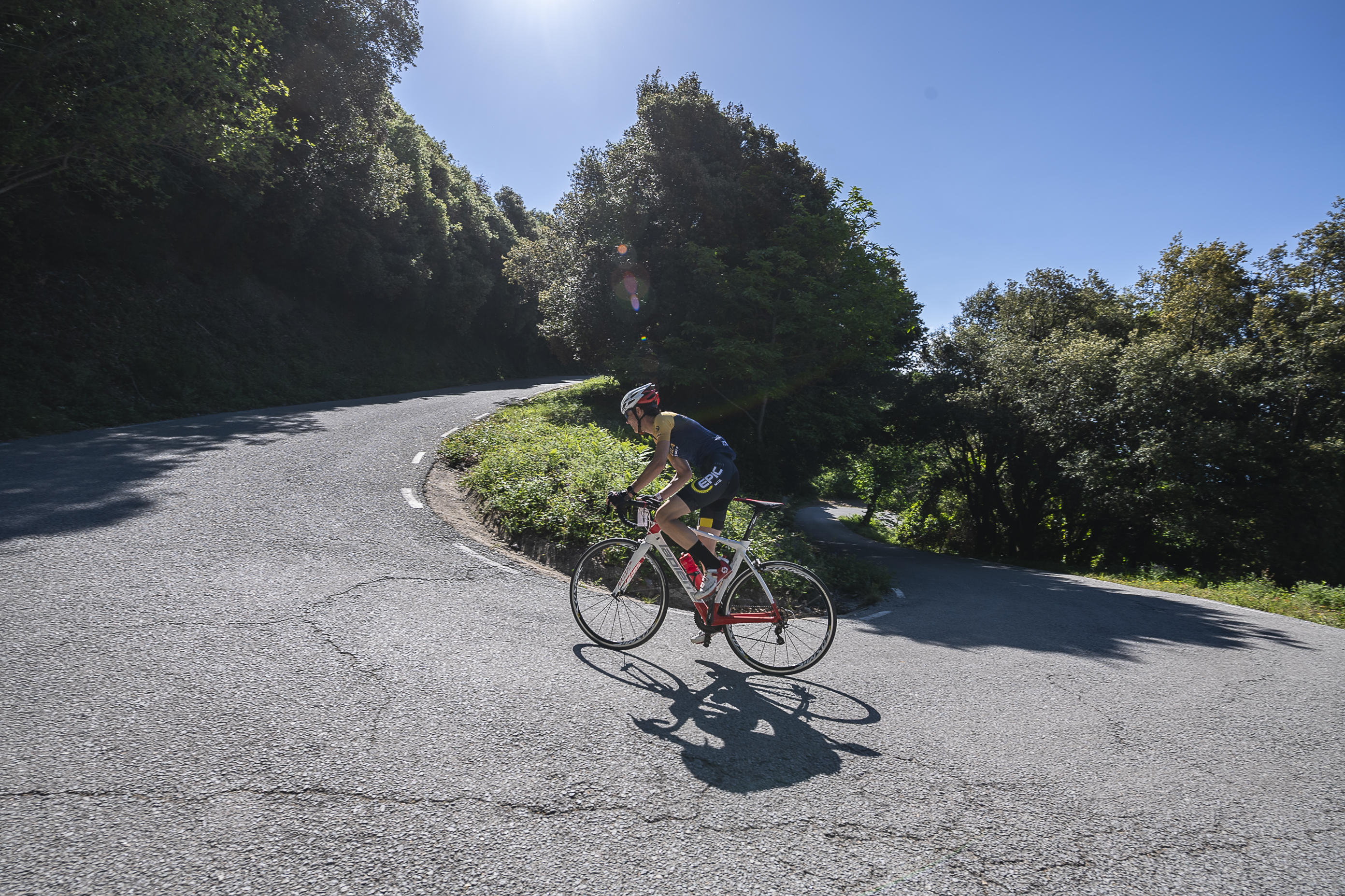 Ciclista tomando una curva en una carretera de montaña
